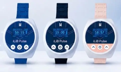 Três aparelhos iLiB Pulse de pulso, com correias azul, preta e rosa e o tempo no display (imagem da Thera Light)